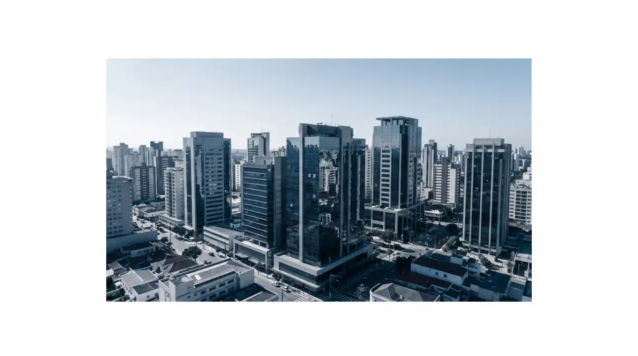 Vista panorâmica de um centro urbano com arranha-céus e edifícios comerciais ao fundo, céu azul e prédios altos em perspectiva na cidade.
